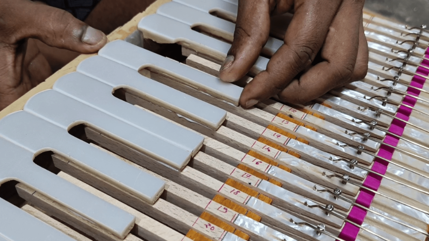 national music craftsman making harmonium