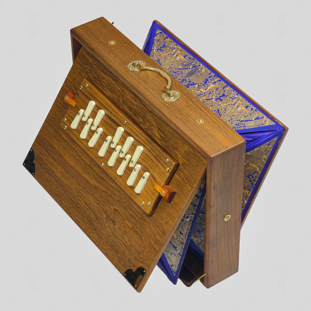 Angled view of a handcrafted Kirtan shruti box with partially expanded blue and gold bellows