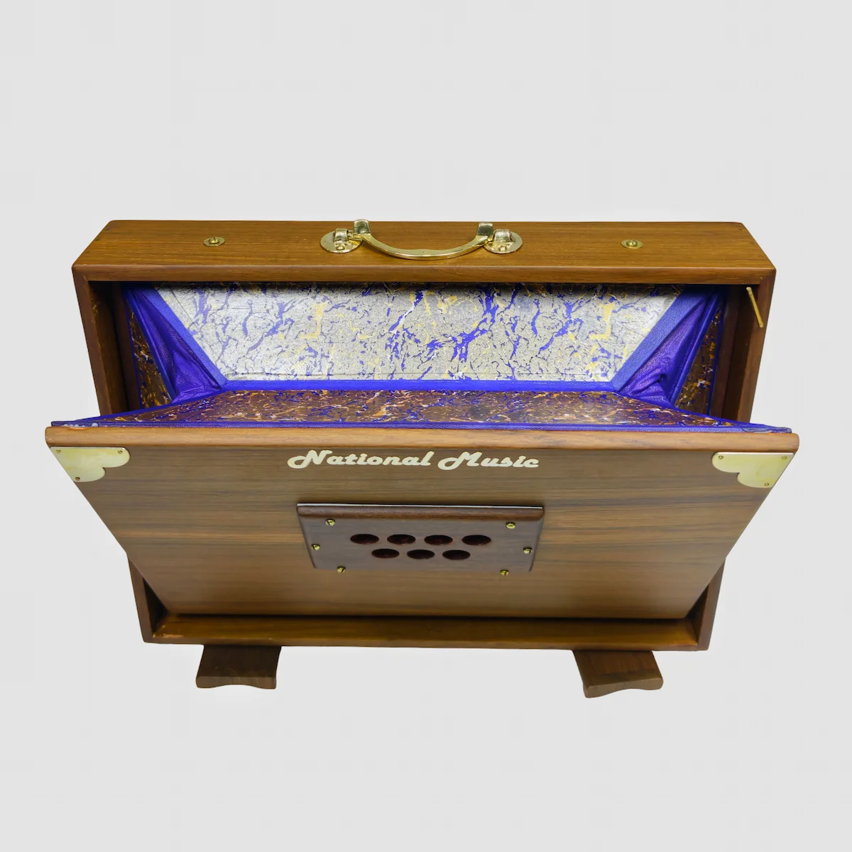 Top-down view inside a National Music WL1 shruti box showing the brand logo and air valves