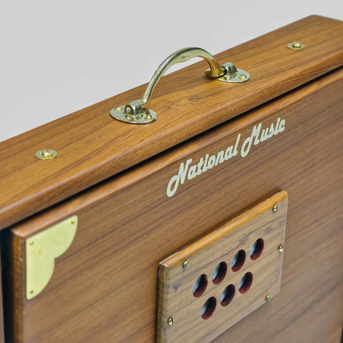 Close-up of the National Music brand engraving and brass carry handle on a Shruti Box