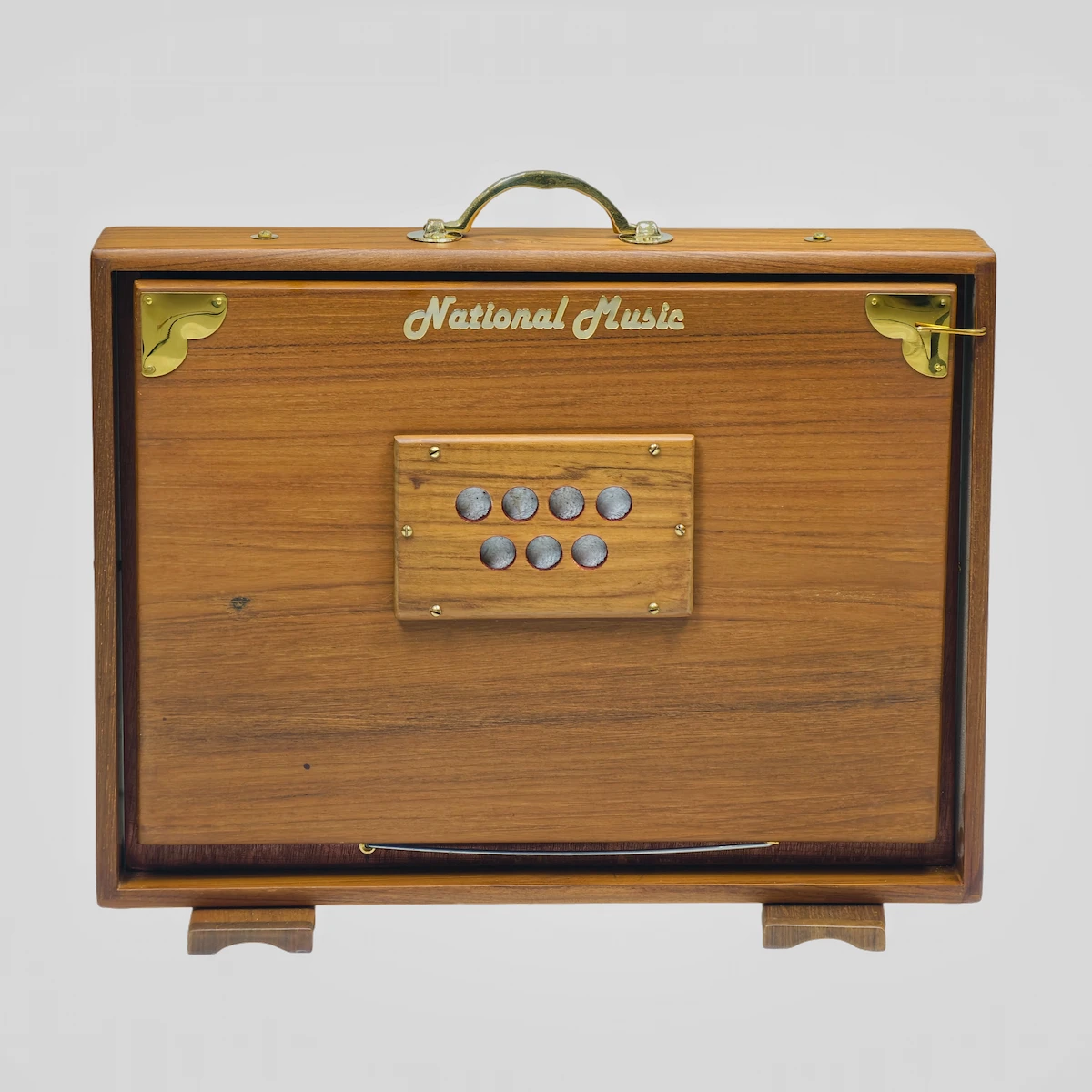 Back side of a wooden Shruti Box showing round sound release holes closed