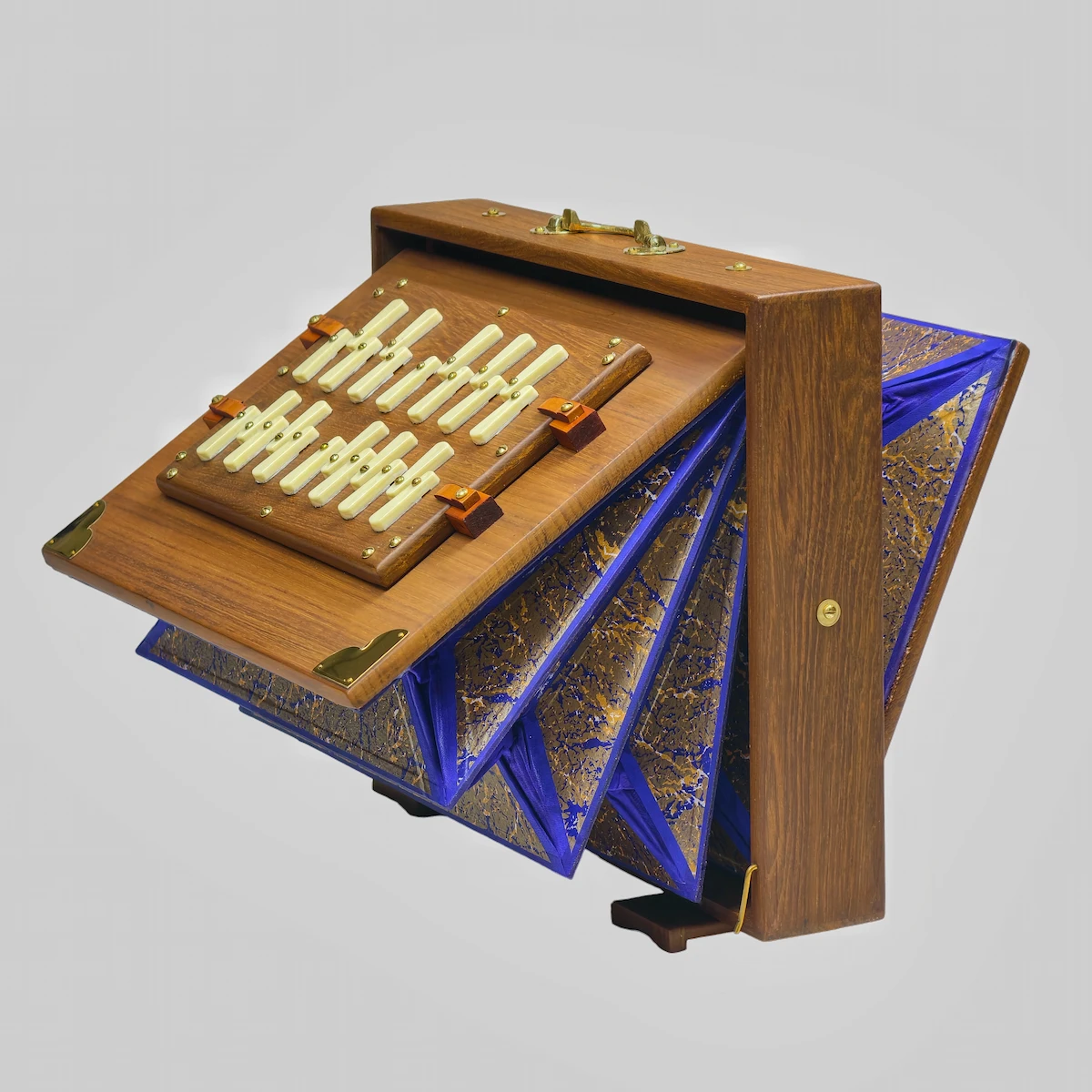 Side angle of a teak Shruti Box with its multi-fold blue bellows fully expanded