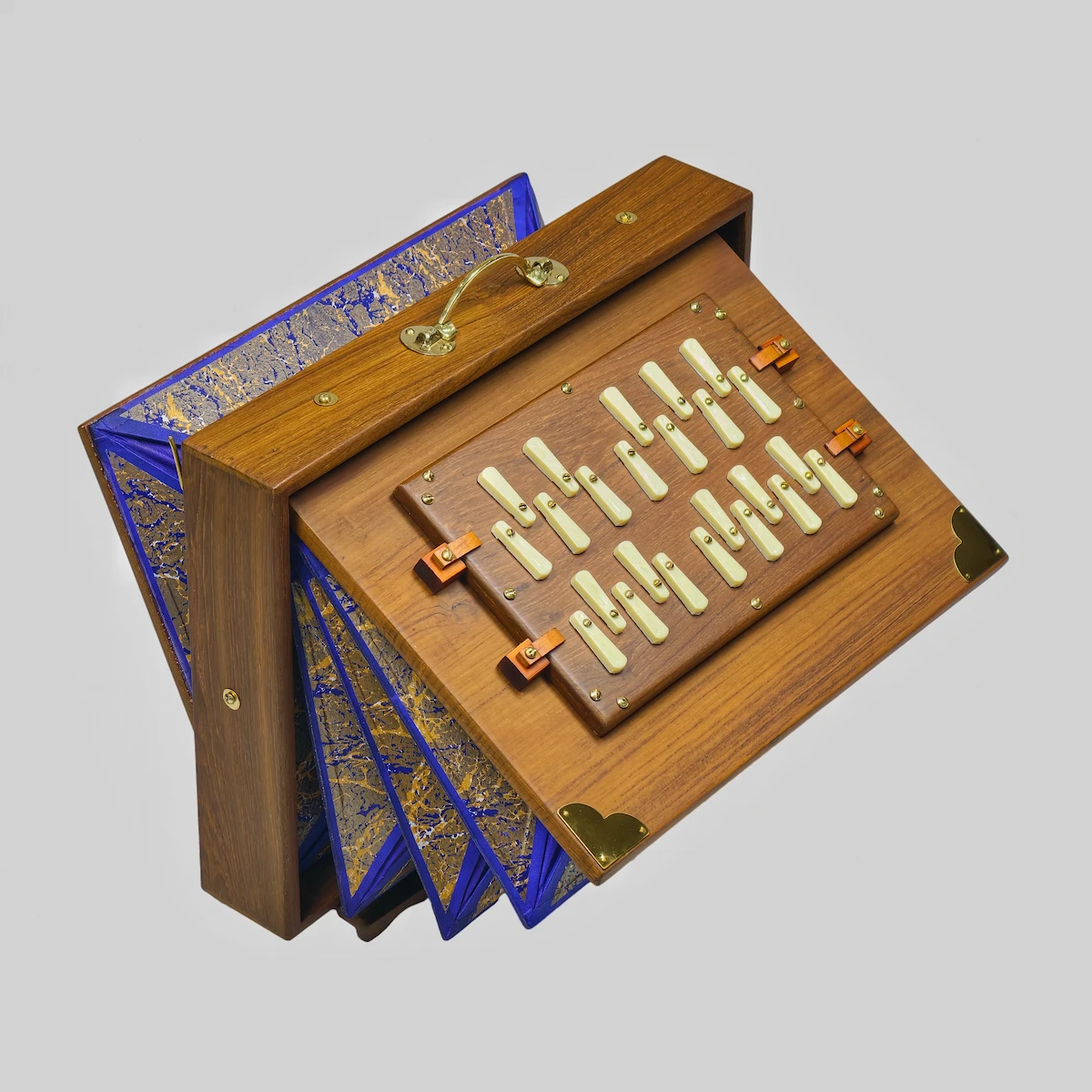 Side profile of a teak Shruti Box highlighting polished brass corner brackets and hinges